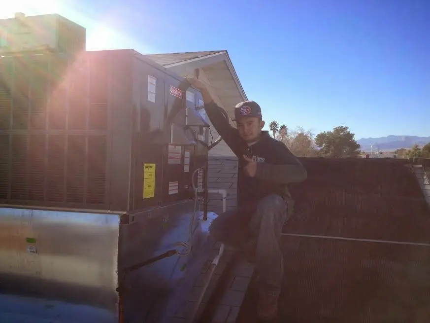 HVAC technician performing Air Duct Repair on a rooftop unit in Melbourne